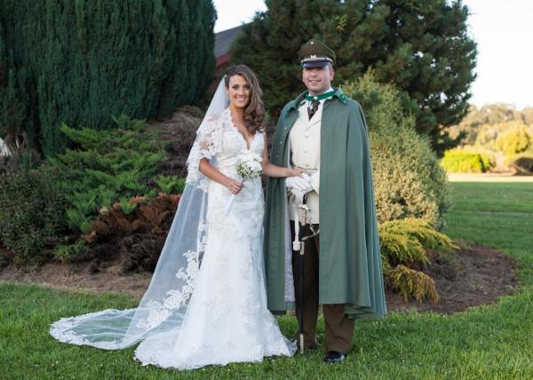pareja de novios en matrimonio militar novio uniformado de gala y novia con Vestido de novia cuello halter y velo largo