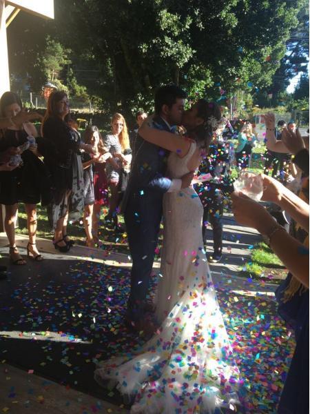 Novios besando mientras amigos celebran el matrimonio