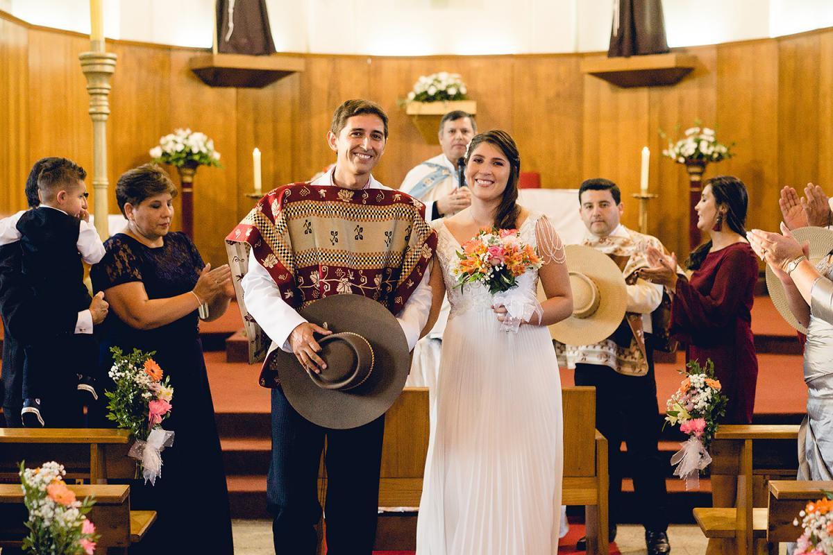casamiento tradicional chileno novio con traje típico chileno de huaso de lujo con poncho y sombrero novia con vestido blanco hecho por somos novios en iglesia con amigos y parientes al rededor 