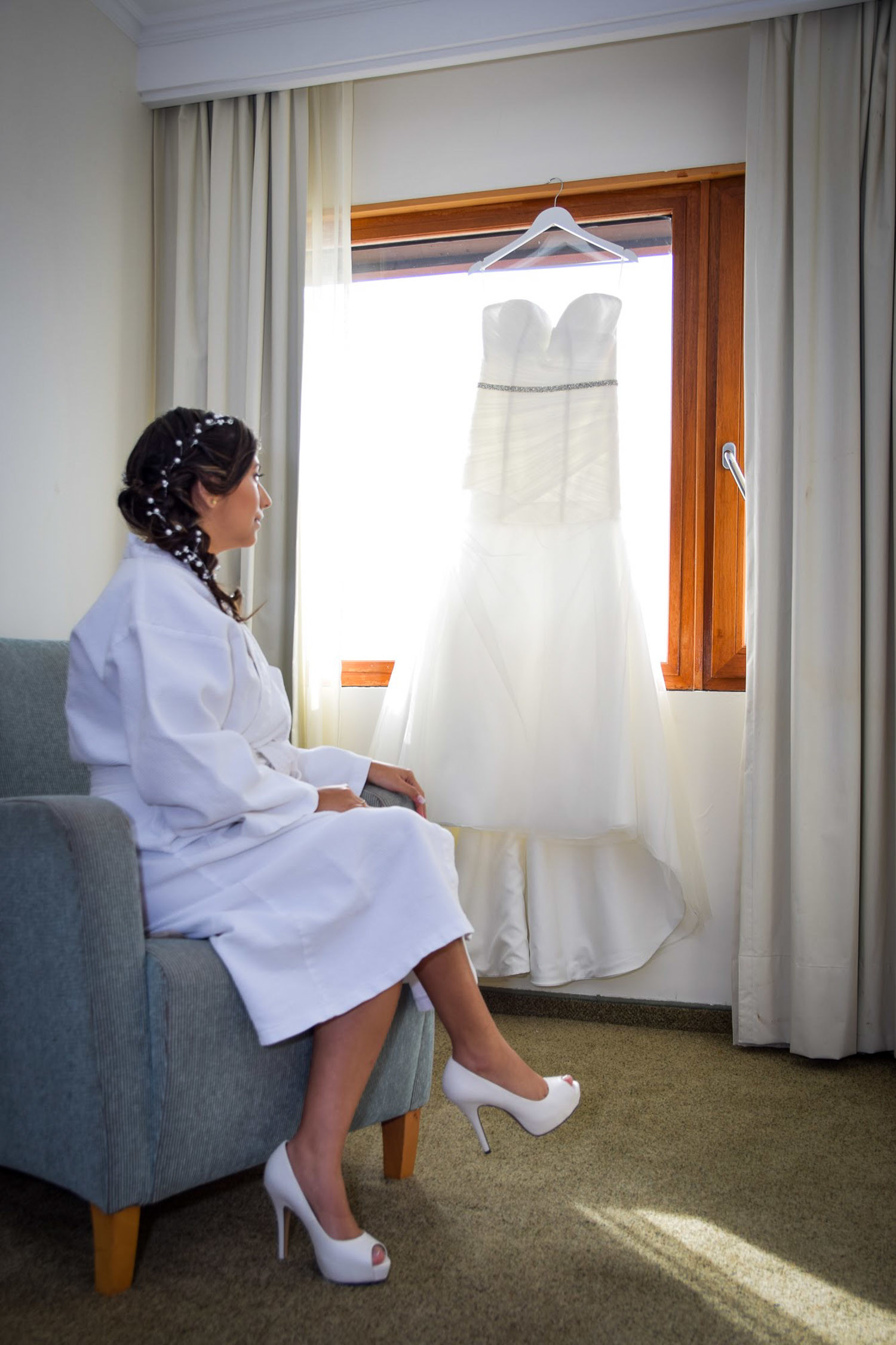 novia sentada en poltrona con zapatos de novia blancos