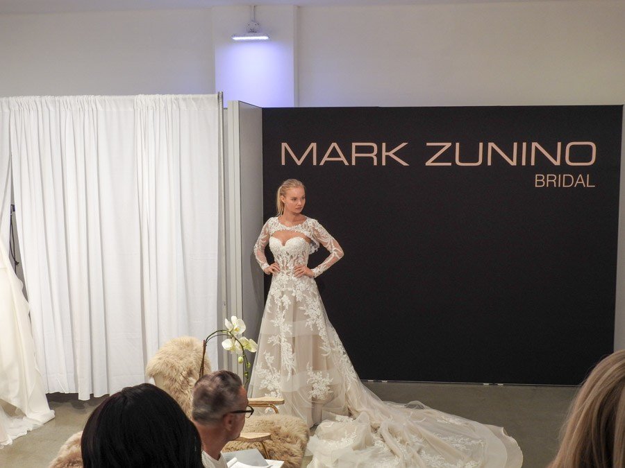 modelo con vestido de novia blanco con con cola y con bolero en el stand de Mark Zunino en el NY Bride Fashion Week 2017