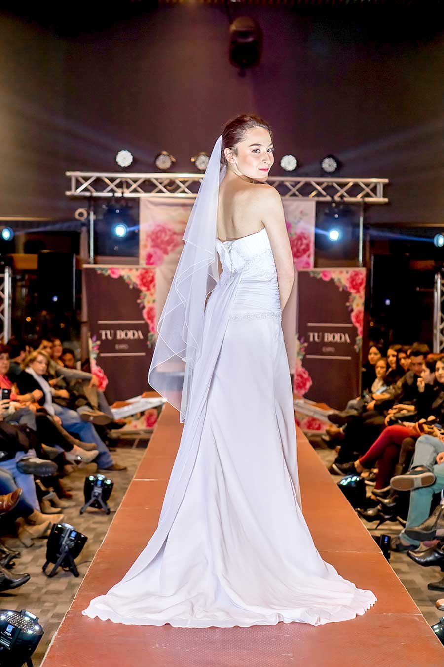 Novia con velo de tul blanco y espalda corset desfilando en expo tu boda 2018