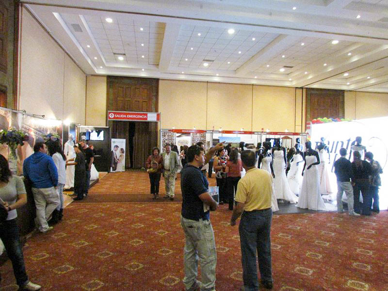Expositores en la exponovios 2012 muchas personas mirando las tiendas de novia y vestidos expuestos en un salón cerrado en santiago